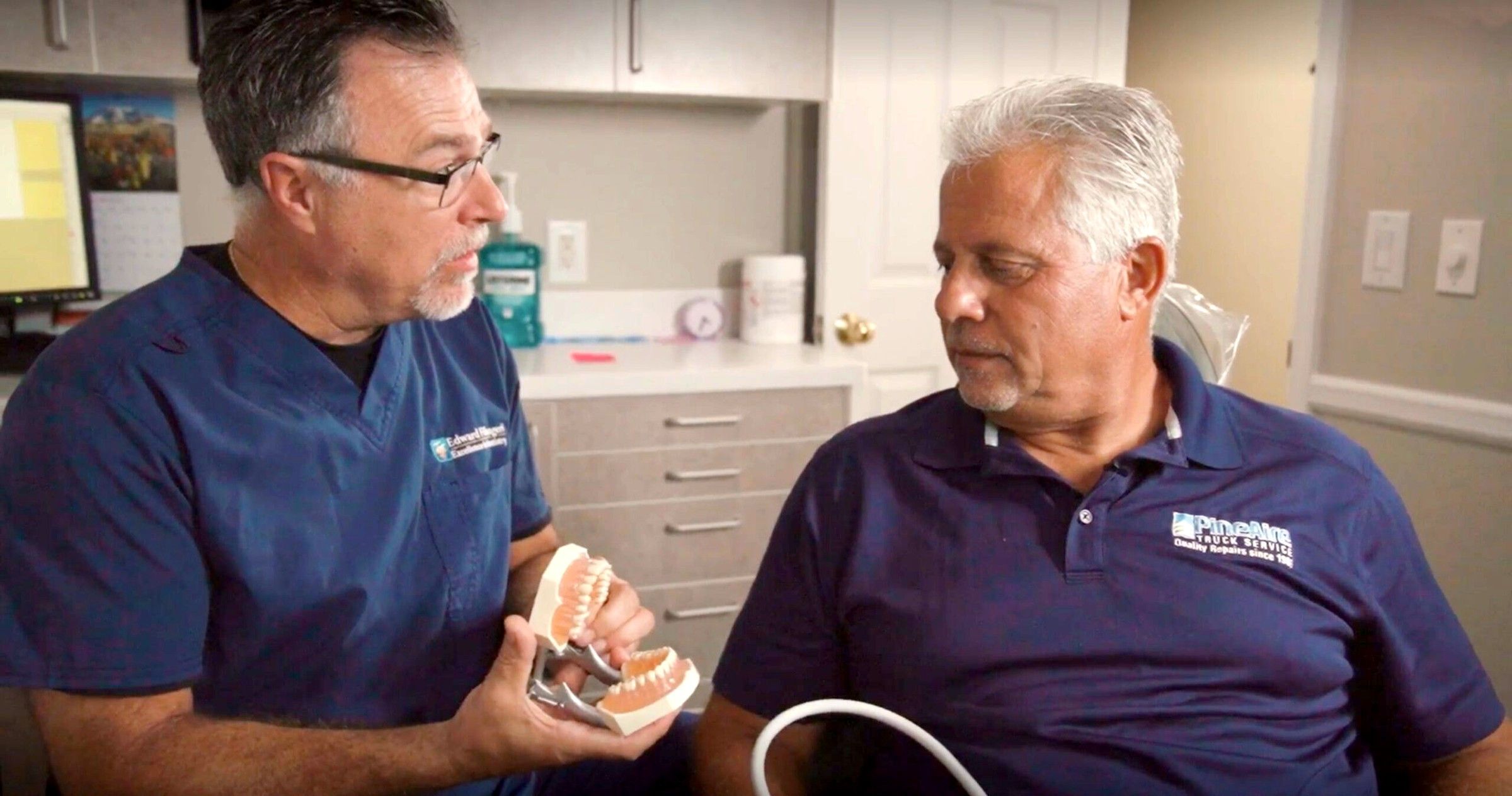 Dr. Ed using a model of the teeth to explain a treatment to a patient
