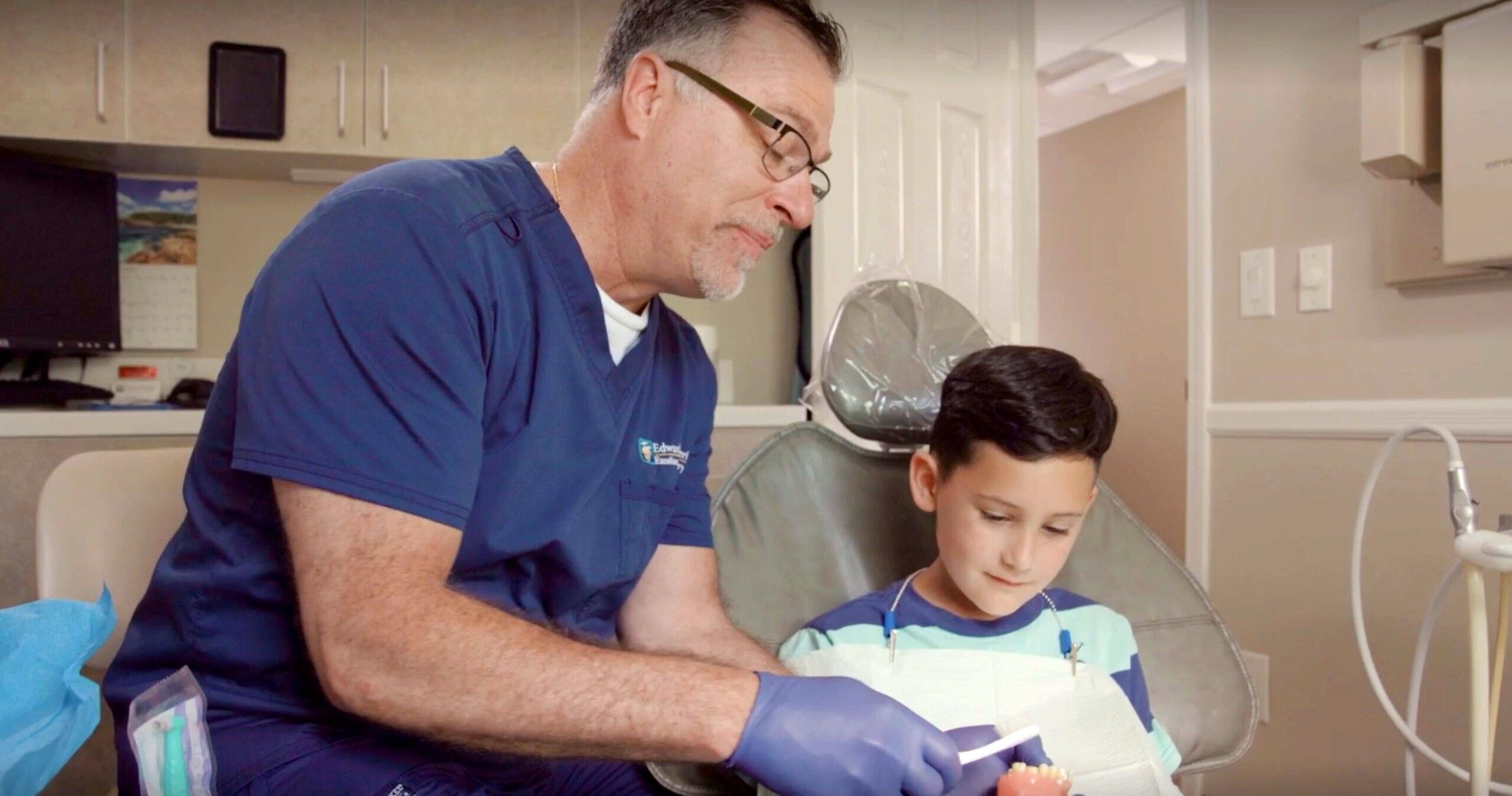 Dr. Ed examining a young patient's teeth